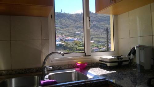 a kitchen with a sink and a window with a view at Apartamento Teixeira 2 in Arco da Calheta