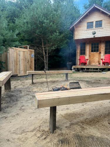 a fire pit in front of a log cabin at Forest Bunkie Trails & Stargazing in Simcoe