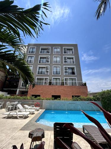 a building with a swimming pool in front of a building at Hotel Macaw Cúcuta in Cúcuta