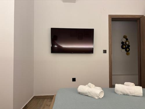 a bedroom with a tv on the wall with towels at Sofia's Home in Chania Town
