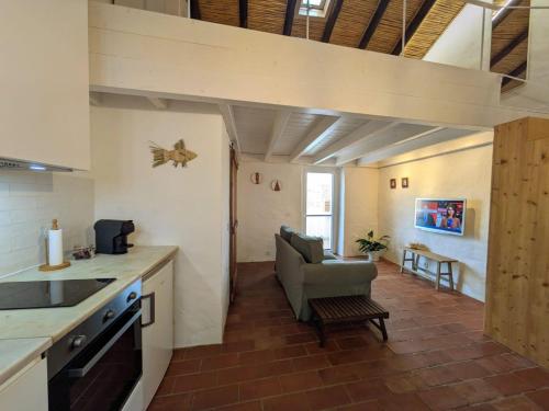 - une cuisine avec un canapé et une chaise dans la chambre dans l'établissement Laranjeira 2 by AlmaAlgarvia, à Santa Bárbara de Nexe