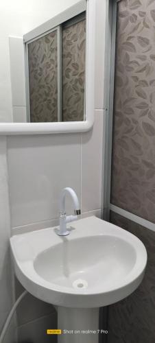 a bathroom with a white sink and a mirror at Hotel Central Abaetetuba in Abaetetuba
