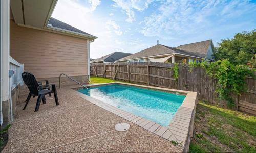 a swimming pool with a chair next to a fence at Peaceful Exec Home w Office Near Everything in Conroe