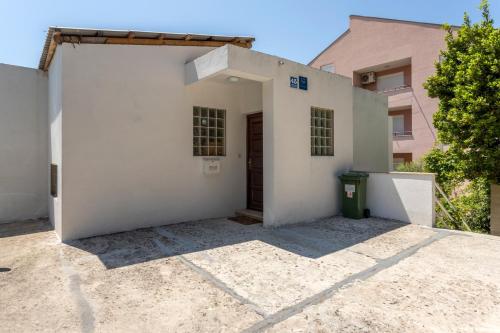 a white building with a door in a yard at Apartment Baska Voda 301a in Baška Voda