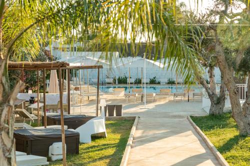 a resort with a pool with tables and chairs at Boomerang Village in Torre Colimena