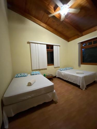 a bedroom with two beds and a ceiling fan at Casa Campestre, Lomas de Holanda in San Cristóbal Verapaz