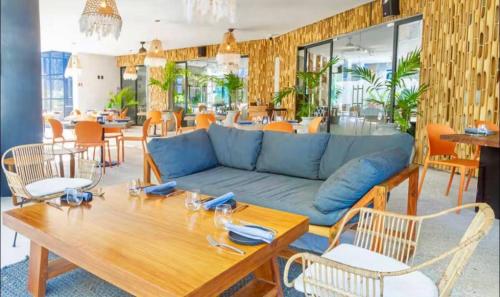 a living room with a blue couch and a table at New! Modern Escape, Tuk Tierra In Tulum in Tulum