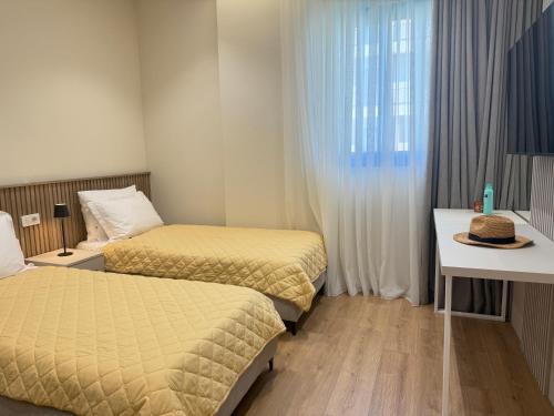 een slaapkamer met 2 bedden en een tafel met een hoed erop bij Casa Magnolia in Vlorë