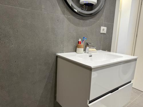 een badkamer met een witte wastafel en een spiegel bij Casa Magnolia in Vlorë