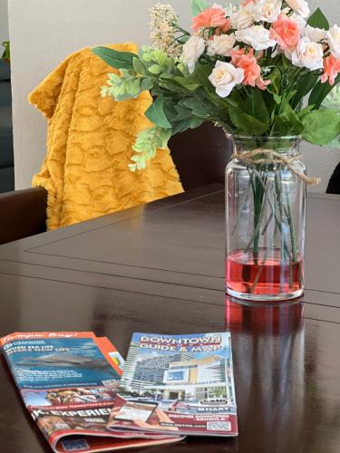 a vase with flowers and a magazine on a table at Busch Gardens Deluxe Edition w/heatedpool in Tampa