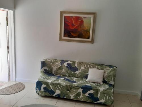 a couch sitting in a living room with a painting at Sunlight Apts in Mount Thompson
