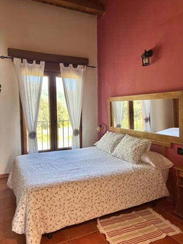 a bedroom with a bed with a large mirror at El Aravalle, Altillo del Aravalle in Umbrías