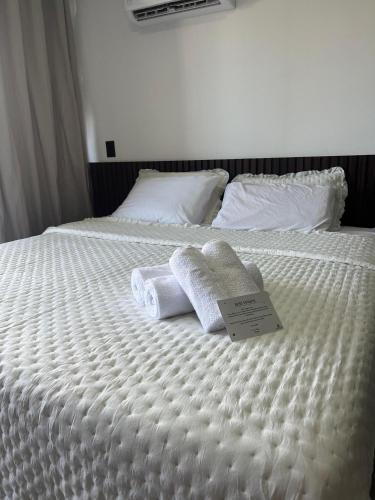 a white bed with towels and a sign on it at Get One - João Pessoa in João Pessoa