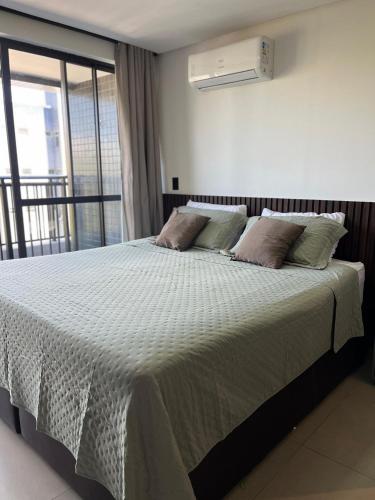 a bedroom with a large bed with a white comforter at Get One - João Pessoa in João Pessoa