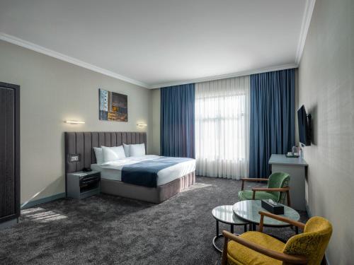 a hotel room with a bed and a table at Novo Sky Hotel in Baku