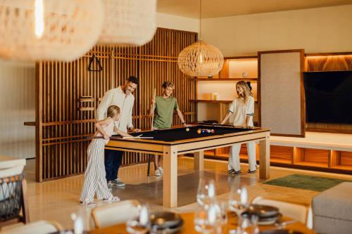 a group of people standing around a pool table at Nobu Hotel Los Cabos in Cabo San Lucas