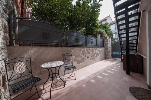a patio with a table and chairs next to a wall at Riva Suite 1 in Komiža