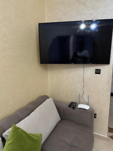 アガディールにあるChambre Cosy chez Redouanのソファと薄型テレビのあるリビングルーム