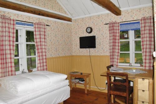1 dormitorio con 1 cama, escritorio y ventanas en Åsens By, en Haurida