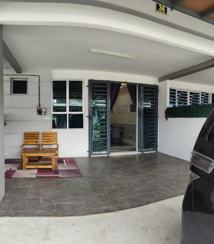 a patio with two wooden chairs and a table at Homestay Ar-Rayyan in Pokok Sena
