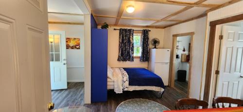 a small room with a bed and a refrigerator at The Seneca Sunset Suites in Burdett
