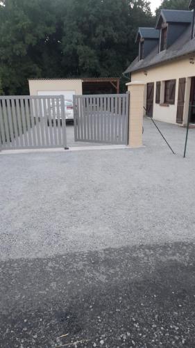 a white fence in front of a house at Maison Normande - Le Mesnil en Ouche in Épinay