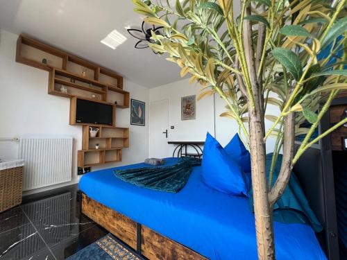 a bedroom with a blue bed with a tree on it at Delrio in Nantes