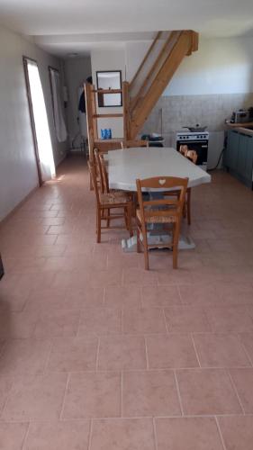 a kitchen with a table and chairs in a room at Maison Normande - Le Mesnil en Ouche in Épinay