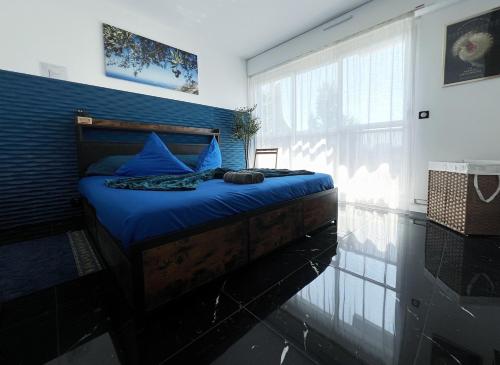 a bedroom with a bed with blue sheets and a window at Delrio in Nantes