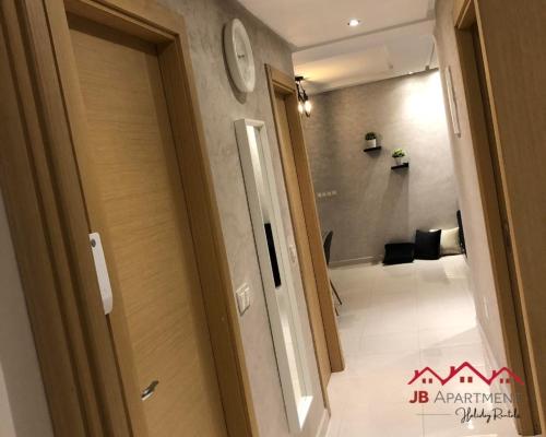 a hallway with a door and a clock on a wall at JB Apartment -B18- in Kenitra
