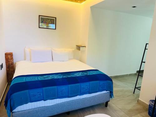 a bedroom with a bed with blue and white sheets at The Quetzal in Cancún