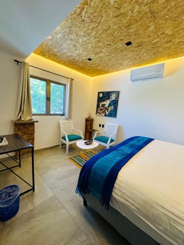 a bedroom with a bed and a table and chairs at The Quetzal in Cancún