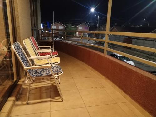 two chairs sitting on a balcony at night at Mi Majestuoso Mirador in Los Andes
