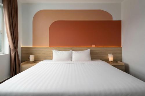 a bedroom with a large white bed with two candles at Truong An NoiBai Airport Hotel in Noi Bai