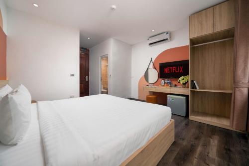 a bedroom with a large white bed and a shelf at Truong An NoiBai Airport Hotel in Noi Bai