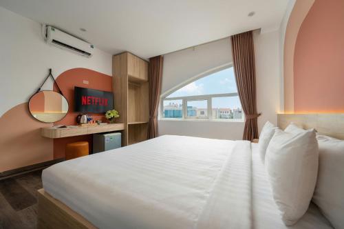a bedroom with a large white bed and a window at Truong An NoiBai Airport Hotel in Noi Bai