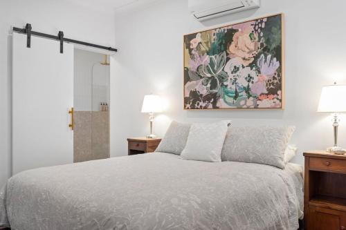 Un dormitorio con una cama y un cuadro en la pared. en Ellangowan, en Toowoomba
