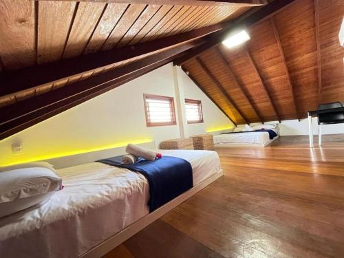 a bedroom with two beds in a room with wooden floors at Reserva BG - Apto Peixe Boi - Frente mar in Barra Grande