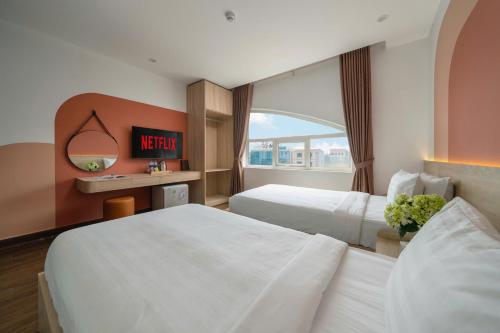 a hotel room with two beds and a window at Truong An NoiBai Airport Hotel in Noi Bai