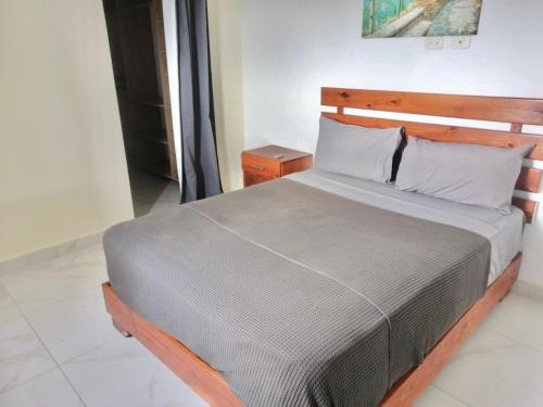 a bedroom with a large bed with a wooden headboard at Nice and Cozy Condo with Pool in Punta Cana