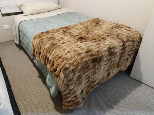 a bed in a room with a brown blanket on it at Mi Majestuoso Mirador in Los Andes