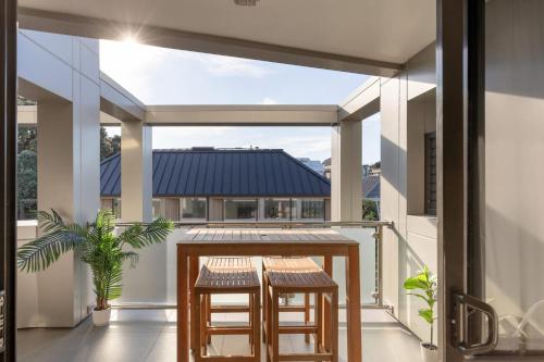 un balcon avec une table et deux tabourets dans l'établissement Cosy Mount Base King Bed Ensuite & Top Location, à Mount Maunganui