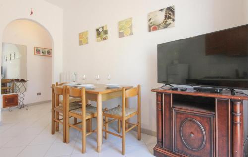 a dining room with a table and a flat screen tv at Stunning Apartment In Agropoli in Agropoli