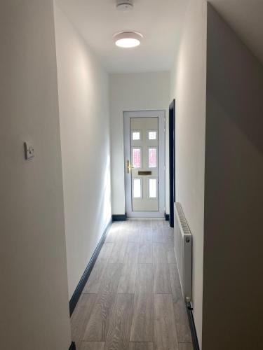 an empty room with a hallway with a door at Rossy Guest House in Stoke on Trent