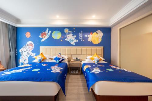 a bedroom with two beds and a blue wall at Rezen Select Shanghai International Resort in Shanghai