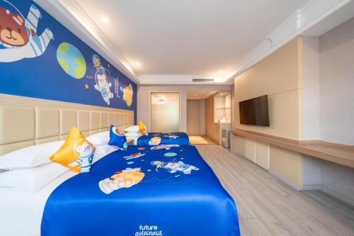 a bedroom with a blue bed with toys on it at Rezen Select Shanghai International Resort in Shanghai