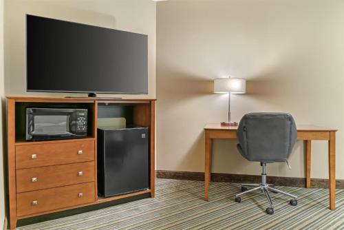 a room with a desk and a television and a chair at Best Western Plus Traverse City in Traverse City