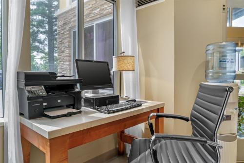 an office with a computer on a desk with a chair at Best Western Plus Traverse City in Traverse City