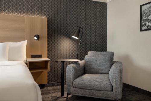 a bedroom with a bed and a chair in a room at Best Western Plus City Centre Centre-Ville in Quebec City
