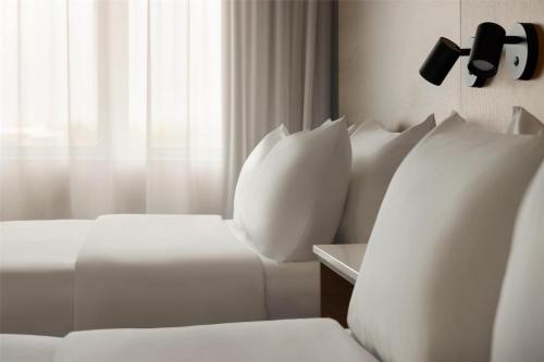 a room with two white beds and a window at Best Western Plus City Centre Centre-Ville in Quebec City